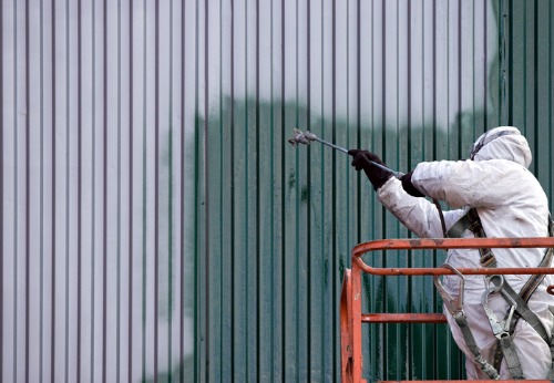 Painting Contractors in Peoria IL applying paint to the side of a building
