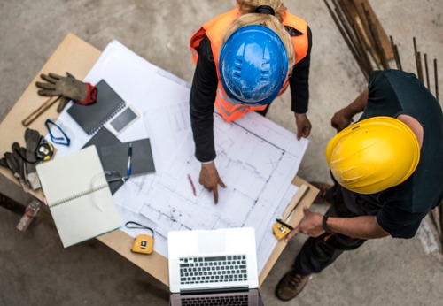 A Contractor in Springfield IL conversing with a worker about the blueprints of a construction job