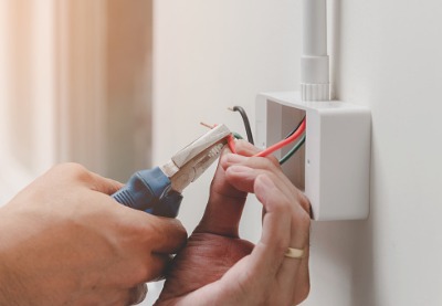 An electrician wiring an outlet, as part of Construction Companies in Springfield IL