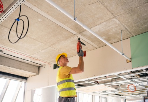 An Interior Contractor in Peoria IL working on the ceiling of an office space in construction