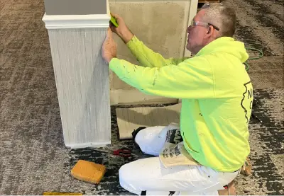 A worker is seen installing trim in an office. Mid-Illinois Companies is a commercial contractor in Macomb IL.